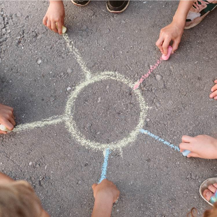Children draw together with colored chalks