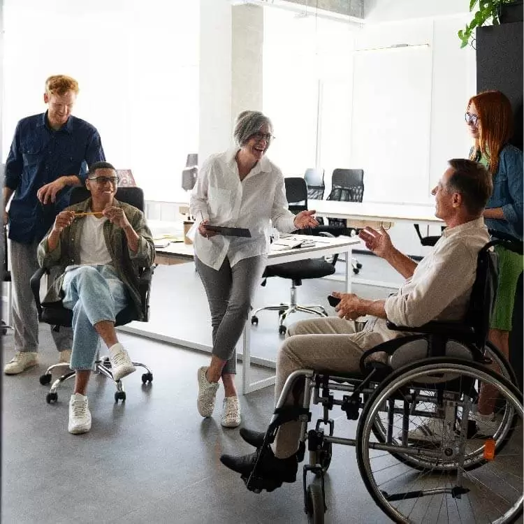 צוות עם משתתף בכיסא גלגלים בעבודה